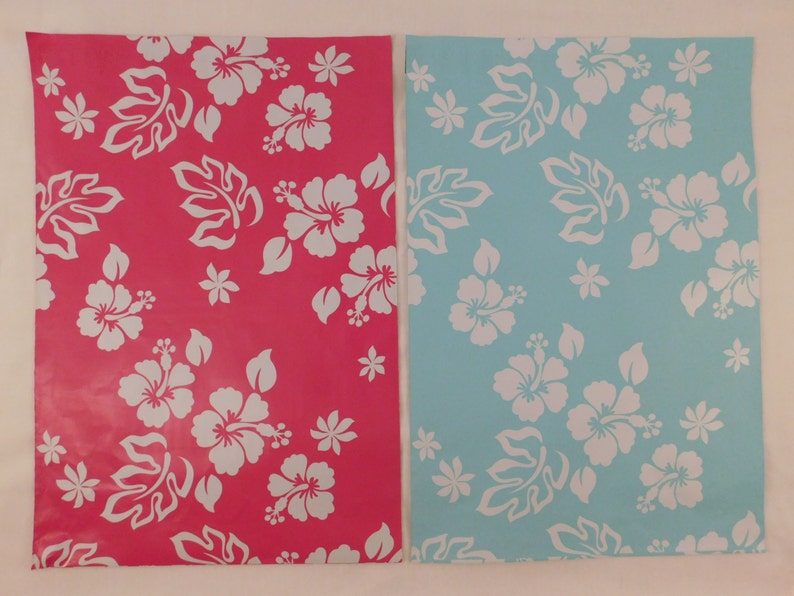 May include: Two sheets of wrapping paper with a white hibiscus flower pattern. One sheet is pink and the other is light blue.
