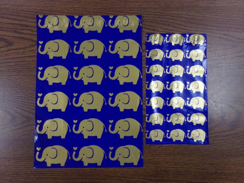 Puede incluir: Dos bolsas de pl&aacute;stico azules con dise&ntilde;os de elefantes dorados. La bolsa m&aacute;s grande mide aproximadamente 25 cm de alto y la m&aacute;s peque&ntilde;a aproximadamente 15 cm de alto.