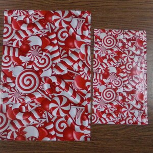 Puede incluir: Dos hojas de papel de regalo rojo y blanco con un patr&oacute;n de bastones de caramelo y menta.