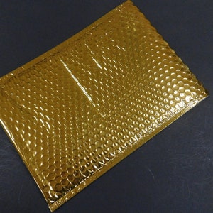 May include: A gold-colored bubble mailer envelope with a textured surface.
