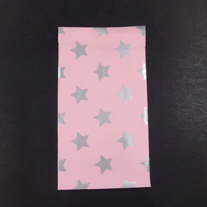 May include: Pink plastic pouch with a silver star pattern.