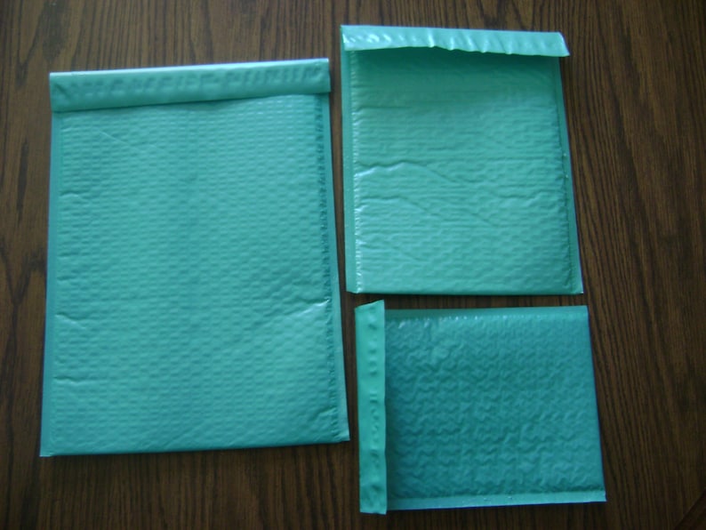 May include: Three teal blue padded envelopes of different sizes. The envelopes are made of a textured material and have a sealed flap.
