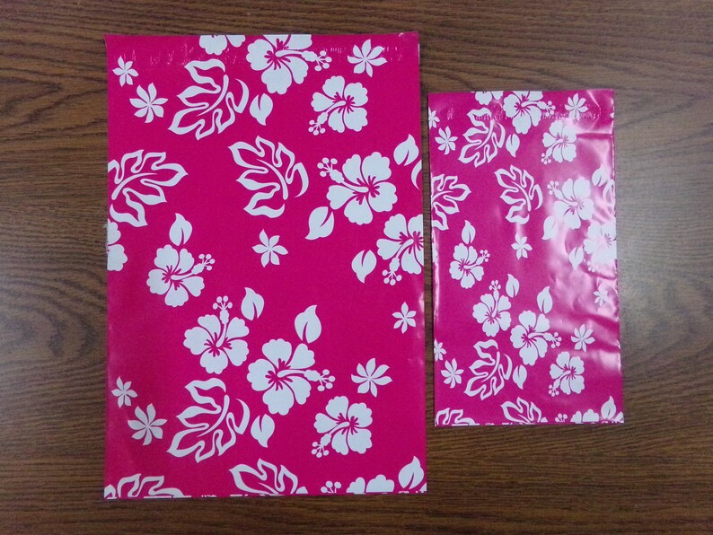 Puede incluir: Dos sobres de env&iacute;o de pl&aacute;stico rosa con un patr&oacute;n de flores de hibisco blancas. El sobre m&aacute;s grande mide aproximadamente 30 cm por 40 cm. El sobre m&aacute;s peque&ntilde;o mide aproximadamente 15 cm por 20 cm.