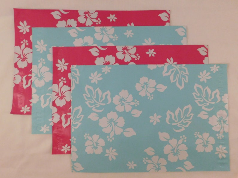 May include: Four colorful mailing envelopes with a tropical floral pattern. The envelopes are blue and pink with white hibiscus flowers.
