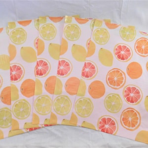 May include: Six pink and white patterned gift bags with a citrus fruit design. The bags feature lemons, oranges, and grapefruits in watercolor style.