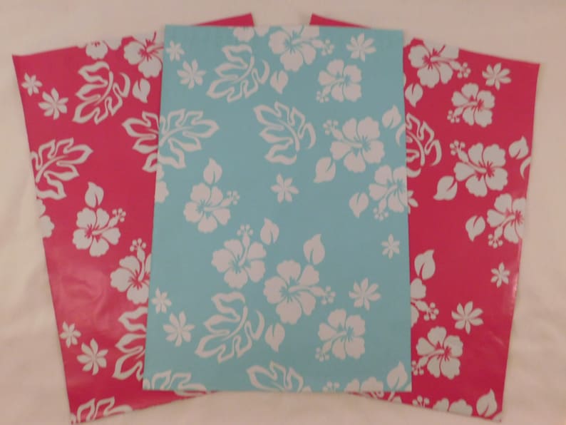 May include: Three sheets of wrapping paper with a tropical floral pattern. The paper is pink and blue with white hibiscus flowers and leaves.