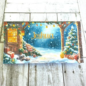 May include: A rectangular Christmas-themed painting featuring a snowy outdoor scene. The artwork depicts a house with a lit doorway, a Christmas tree, and the name "Joshua" in gold script. Presents and festive lights adorn the scene.