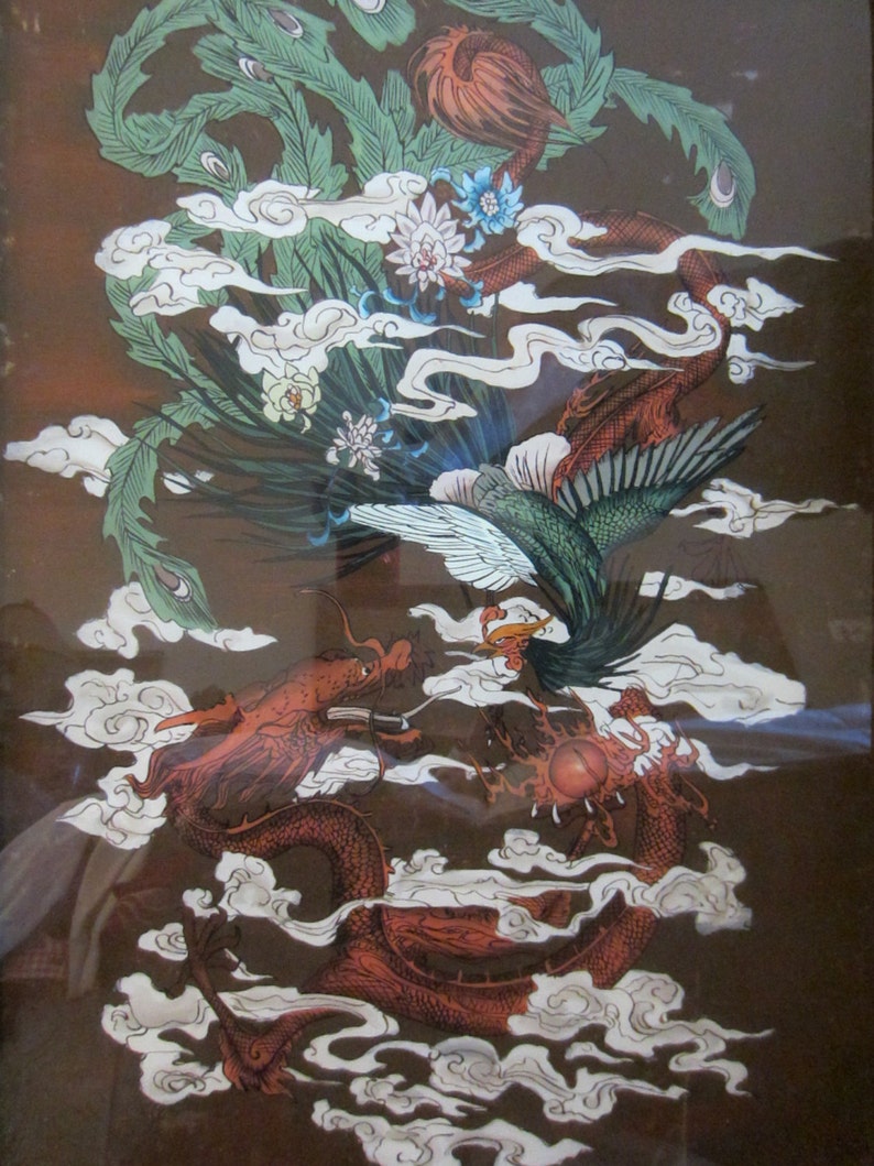 May include: A framed print featuring a detailed illustration of a red dragon and a green phoenix intertwined amidst white stylized clouds. The dragon is positioned at the bottom, while the phoenix soars above, surrounded by floral accents.
