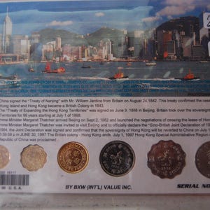May include: A commemorative item featuring a cityscape with boats and a timeline of Hong Kong's history. Includes several coins and text indicating it's a limited edition from 1981.