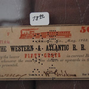 May include: An antique Western & Atlantic R.R. fifty-cent note from May 1862, featuring a train illustration in red. The note includes text such as "Atlanta, Ga." and "will pay the bearer FIFTY CENTS".