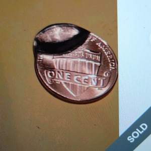 May include: A copper one-cent coin with the words "ONE CENT" prominently displayed. The coin has a dark, possibly melted, substance on its top edge. The background is a warm, golden-brown color.