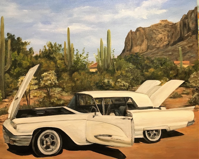 Pu&ograve; includere: Dipinto a olio di un'auto bianca classica con cofano e portiere aperte, ambientato in un paesaggio desertico con cactus e montagne. I dettagli dell'auto sono visibili, immersi nella luce naturale.