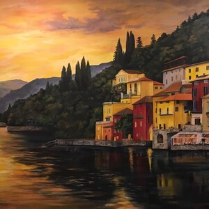 Pu&ograve; includere: Dipinto a olio di un villaggio costiero al tramonto. Edifici con facciate gialle, rosse e arancioni costeggiano il lungomare. L'acqua riflette i colori caldi del cielo e degli edifici. Alti alberi verde scuro sono sulla collina.