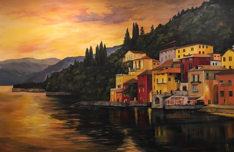 Pu&ograve; includere: Dipinto a olio di un villaggio costiero al tramonto. Edifici con facciate gialle, rosse e arancioni costeggiano il lungomare. L'acqua riflette i colori caldi del cielo e degli edifici. Alti alberi verde scuro sono sulla collina.
