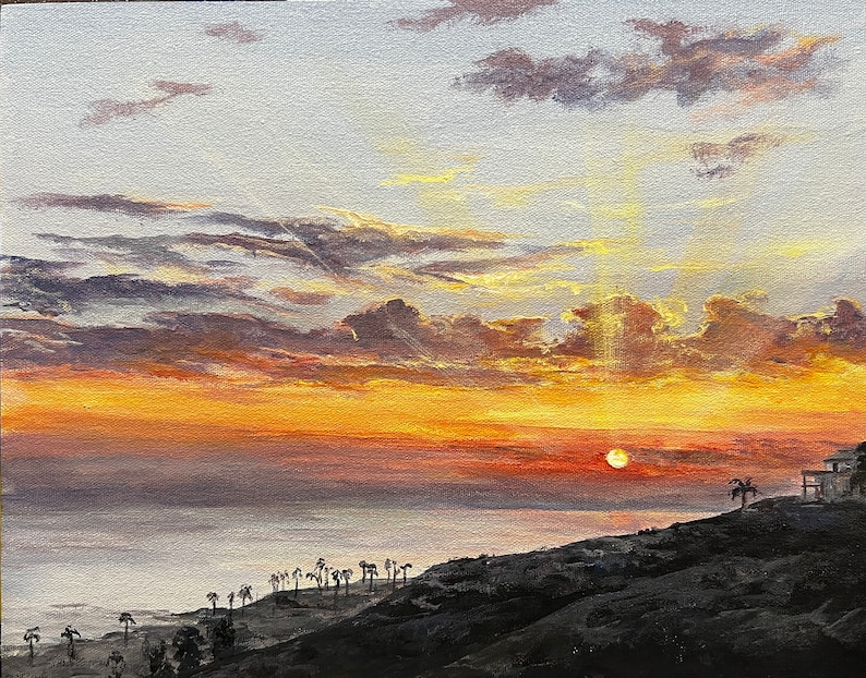 Pu&ograve; includere: Un dipinto a olio raffigura un tramonto sull'oceano. Il cielo &egrave; pieno di tonalit&agrave; arancioni, gialle e viola, con il sole che tramonta all'orizzonte. Palme e una casa silhouette si trovano su una collina scura.