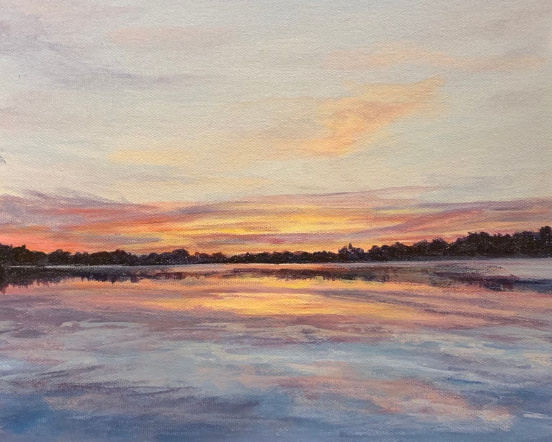 Pu&ograve; includere: Dipinto a olio di un tramonto su un lago. Il cielo passa dal blu pallido a vibranti tonalit&agrave; arancioni e rosa. L'acqua riflette il cielo colorato, con una linea di alberi scuri all'orizzonte.