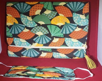 May include: A rectangular fabric pouch with a zipper closure and a yellow tassel, featuring a repeating pattern of colorful Japanese folding fans in orange, yellow, teal, and green on a black background, paired with a matching face mask.