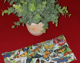 May include: A rectangular fabric pouch featuring a light blue background with a dense, colorful pattern of various butterflies and green foliage. The butterflies are depicted in shades of orange, yellow, blue, black, and red.