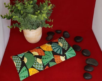 May include: A rectangular fabric eye pillow featuring a black background with a repeating pattern of colorful folding fans in shades of green, orange, and yellow, decorated with intricate floral and geometric motifs throughout the design.