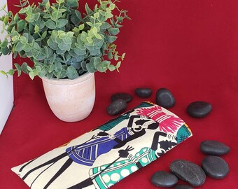 May include: A rectangular fabric pouch featuring a cream-colored background with a graphic print of stylized figures in blue, green, and pink attire. The figures are depicted with elongated limbs and are carrying items on their heads. The pouch has a flat, elongated shape.