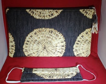 May include: A rectangular zippered pouch and a matching pleated face mask, both featuring a dark charcoal gray fabric with a repeating pattern of large, circular, cream-colored dandelion-like designs with fine, radiating lines.
