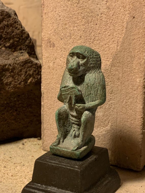 Egyptian statue of Thoth - God of writing, wisdom, records. Baboon form holding the eye of Horus