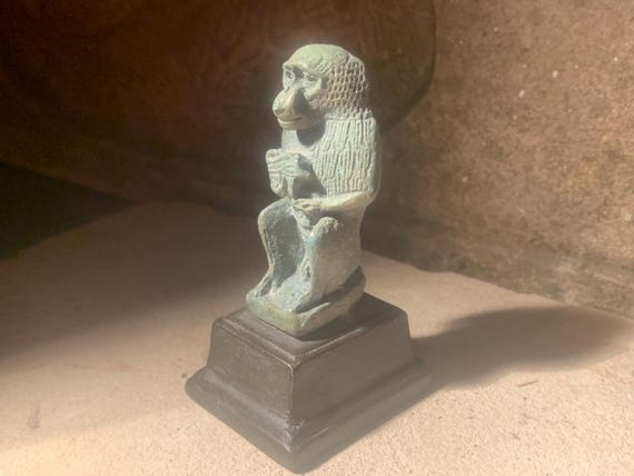 Egyptian statue of Thoth - God of writing, wisdom, records. Baboon form holding the eye of Horus