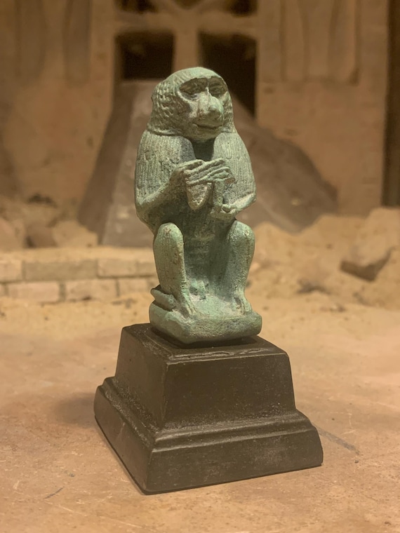 Egyptian statue of Thoth - God of writing, wisdom, records. Baboon form holding the eye of Horus
