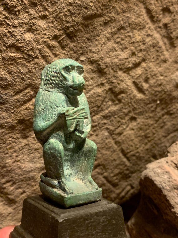 Egyptian statue of Thoth - God of writing, wisdom, records. Baboon form holding the eye of Horus