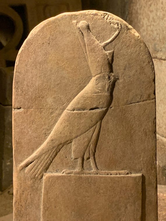 Ancient Egyptian god Horus wearing the double crown of upper and lower Egypt perched atop a shrine. Mounted desk top relief carving replica