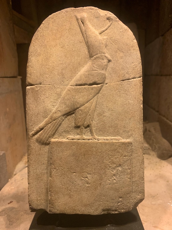 Ancient Egyptian god Horus wearing the double crown of upper and lower Egypt perched atop a shrine. Mounted desk top relief carving replica