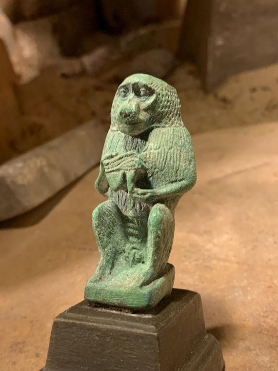 Egyptian statue of Thoth - God of writing, wisdom, records. Baboon form holding the eye of Horus