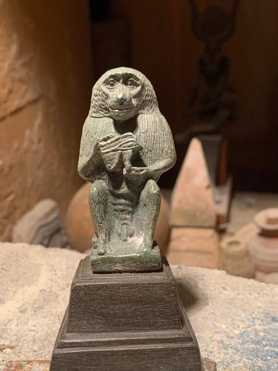 Egyptian statue of Thoth - God of writing, wisdom, records. Baboon form holding the eye of Horus