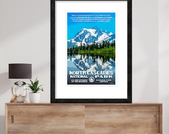 May include: A vintage travel poster for North Cascades National Park. The poster features a scenic view of a mountain range reflected in a lake. The text on the poster reads "North Cascades National Park, US Department of the Interior, National Park Service".