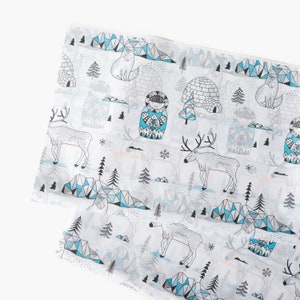 May include: White fabric with a repeating pattern of blue and black illustrations of reindeer, igloos, mountains, and trees. The fabric has a subtle geometric pattern.