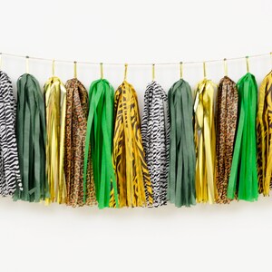 May include: A garland of tissue paper tassels in green, gold, leopard print, and zebra print.