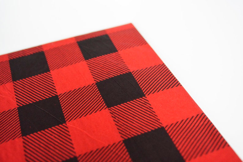 May include: Red and black buffalo plaid fabric with a textured surface.