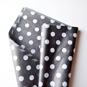 May include: Black tissue paper with white polka dots, folded in half.