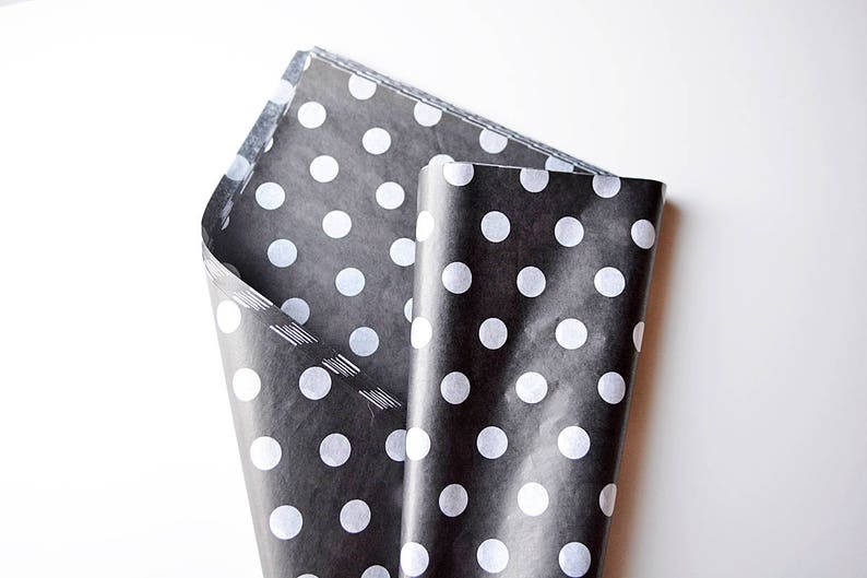May include: Black tissue paper with white polka dots, folded in half.