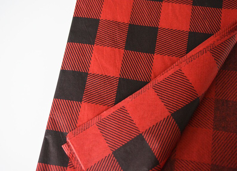 May include: Red and black buffalo plaid tissue paper. The paper is folded in half and the pattern is visible on both sides.