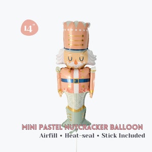 May include: A 14-inch mini pastel nutcracker balloon. The balloon is peach, gold, and mint green, with a nutcracker design. The text "MINI PASTEL NUTCRACKER BALLOON" is displayed below the balloon, along with "Airfill • Heat-seal • Stick Included."