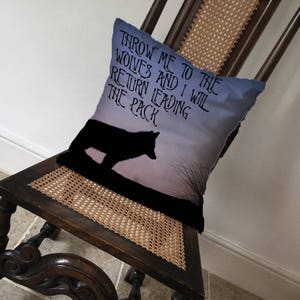 May include: A throw pillow with a wolf silhouette against a purple and blue gradient background. The text on the pillow reads "Throw me to the wolves and I will return leading the pack."