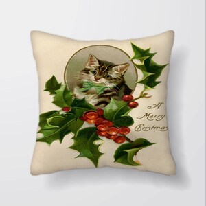 Puede incluir: Una tarjeta de Navidad vintage con un lindo gato atigrado con un lazo verde, rodeado de acebo y bayas rojas. La tarjeta dice "A Merry Christmas".