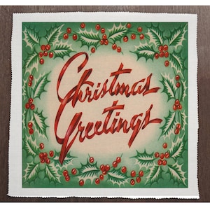 May include: A vintage Christmas greeting card with a green background and a red holly wreath. The text "Christmas Greetings" is written in red cursive lettering.