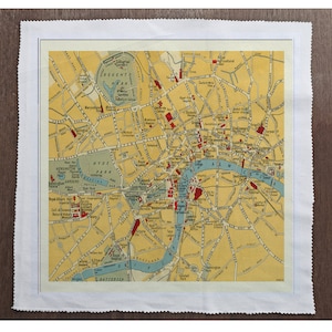 May include: A vintage map of London, England, with a yellow background and blue and red markings. The map shows the Thames River, Hyde Park, Regent's Park, and other landmarks.