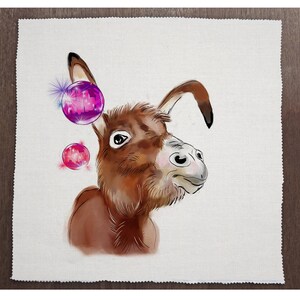 以下が含まれることがあります： 頭の上にピンクと紫の球体がある茶色と白のロバ。ロバは右を見ていて、鼻に白い斑点がある。