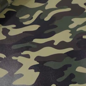 May include: Camouflage pattern fabric in shades of green, brown, and tan. The design features irregular, organic shapes, creating a classic military-inspired aesthetic. The fabric appears to be a durable material, suitable for various applications.
