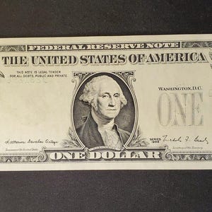 May include: A United States one-dollar bill featuring a portrait of George Washington. The bill is cream-colored with black ink and includes the text "Federal Reserve Note" and "One Dollar."
