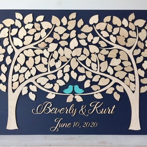 Wedding guest book alternative in 3D wood made with two trees on a navy blue background with turquoise birds and fully customized details of the couple and wedding date