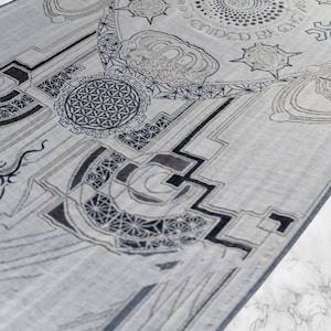 May include: A gray and white patterned rug with geometric designs and the text "Guided by the Light" in a circle.